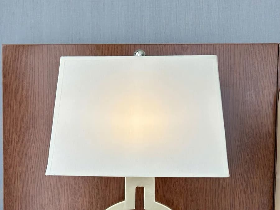 A fabric bedside lamp shade built to fit an existing nightstand base, an example of the kind of piece a re-cover restores