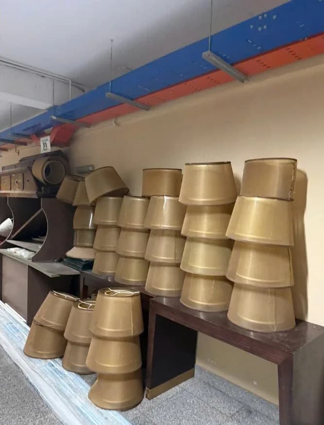 Chụp đèn vải vàng xếp chồng thành cột dọc theo tường trong kho