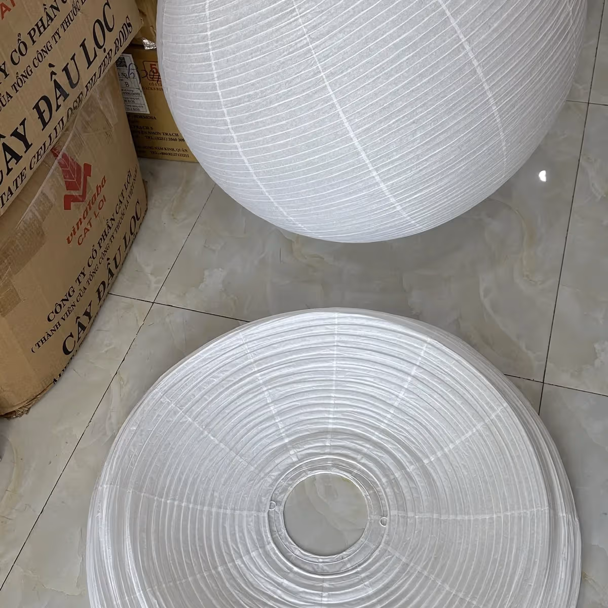 A wabi-sabi lamp shown both expanded and folded flat, showing the collapsible frame structure