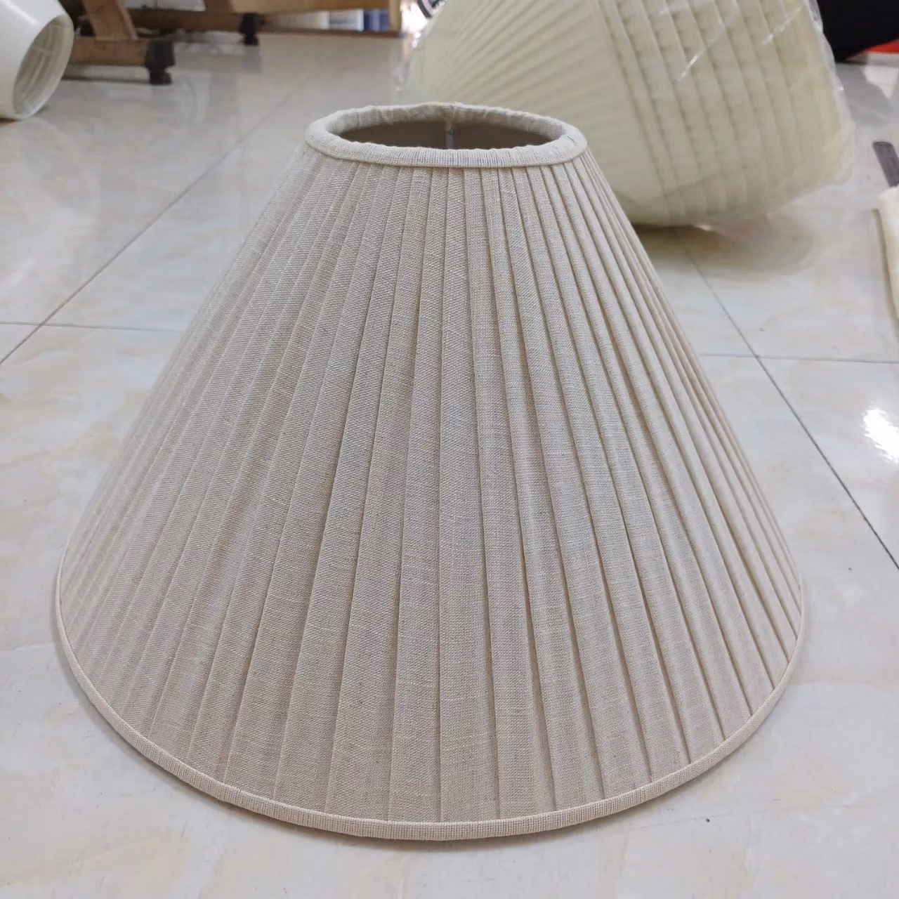 Chụp đèn vải dáng nón xếp ly khổ lớn đặt trên nền gạch